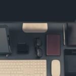 Tablet, phone and keyboard on a dark desk
