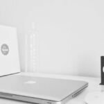 Laptop with a product box on a white desk