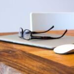 Laptop, glasses and mouse on a desk